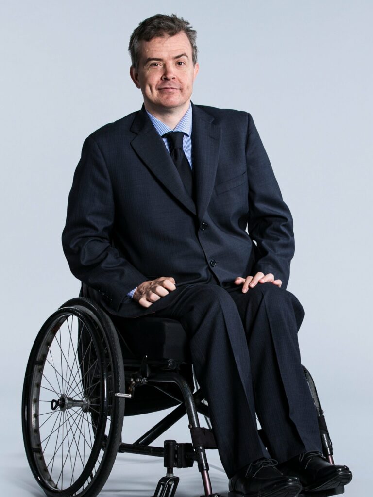 Dr Ben Gauntlett in a wheelchair and a suit